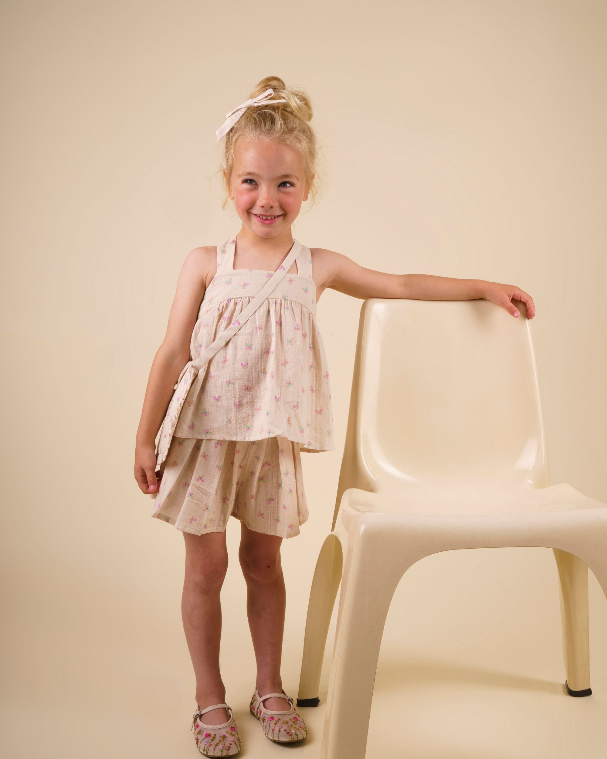 Early Sunday, Solal Skort in Butterflies print, made from Printed Cotton Tiny Swiss Dobby fabric, featuring a flared skirt overlay with attached shorts & elastic waistband, shown in a front view of a model wearing it in a studio setting