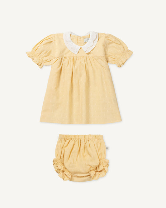 Early Sunday, Sukie Baby Dress & Bloomer in Vanilla color, made from Cotton Dobby Swiss Dots fabric, featuring flared dress with a relaxed fit for ease of movement, matching bloomer with an elasticated waistband for comfort and flexibility., shown in a front flat-lay view