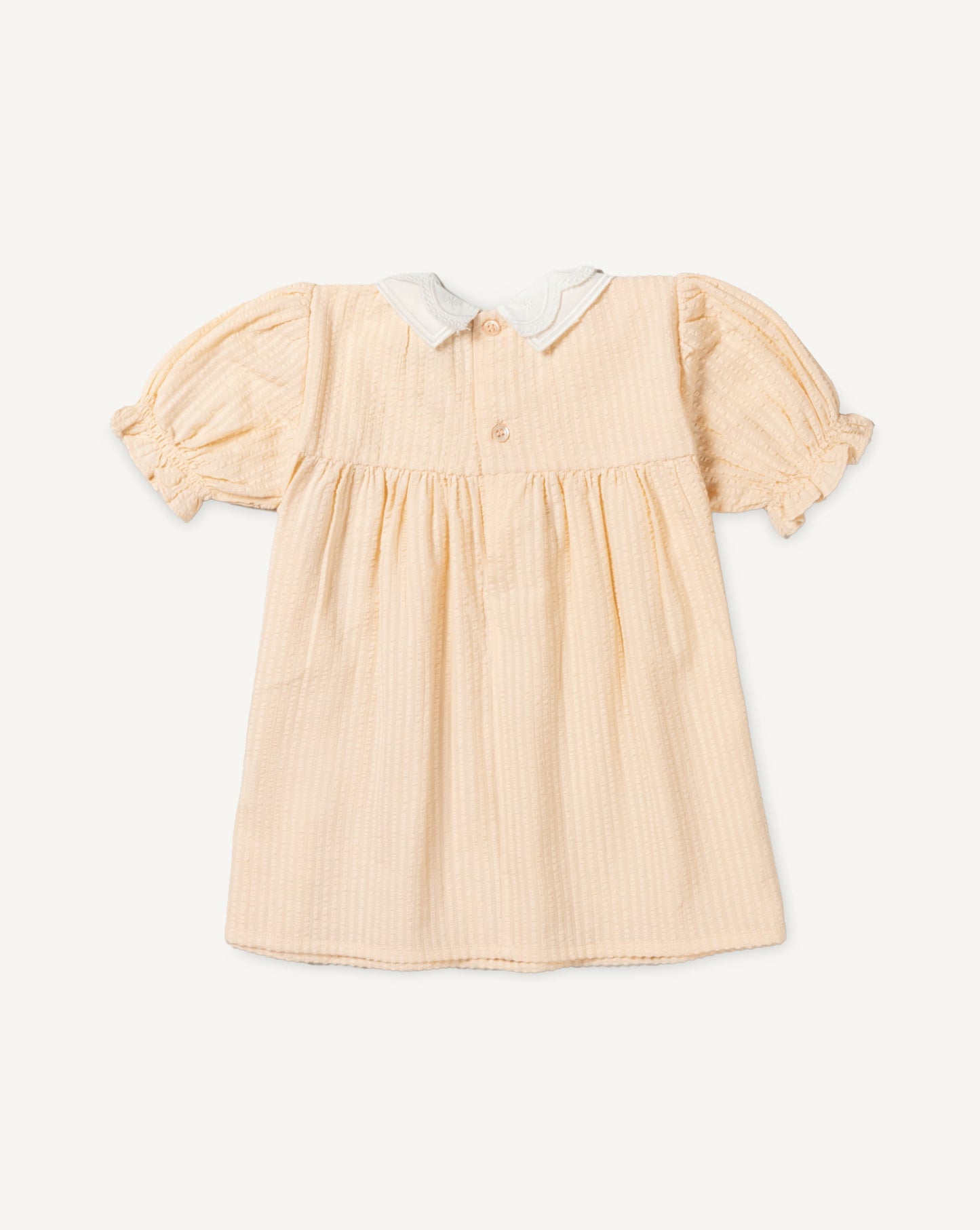 Early Sunday, Sukie Baby Dress & Bloomer in Warm Sand color, made from Cotton Seersucker fabric, featuring flared dress with a relaxed fit for ease of movement, matching bloomer with an elasticated waistband for comfort and flexibility., shown in a back flat-lay view