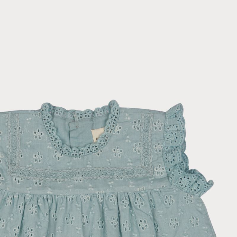Early Sunday, Susie Baby Dress & Bloomer in Sea Dream color, made from All-Over Eyelet Embroidered Cotton Schifflie fabric, featuring flared dress with a relaxed fit for ease of movement, matching bloomer with an elasticated waistband for comfort and flexibility, shown in a closeup flat-lay view