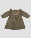 Early Sunday, Suzanne Dress in Dried Leaf, made from Cotton Double Gauze fabric, featuring classic silhouette with floral embroidery around the yoke and ruffle detailing, shown in a back flat-lay view