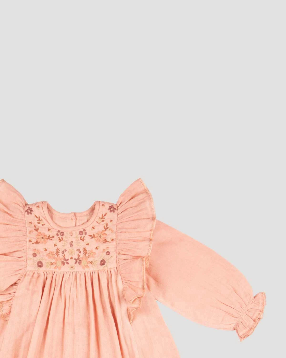 Early Sunday, Suzanne Dress in Dusty Pink, made from Cotton Double Gauze fabric, featuring classic silhouette with floral embroidery around the yoke and ruffle detailing, shown in a closeup flat-lay view