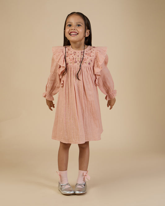 Early Sunday, Suzanne Dress in Dusty Pink, made from Cotton Double Gauze fabric, featuring classic silhouette with floral embroidery around the yoke and ruffle detailing, shown in a front view of model wearing it