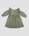 Early Sunday, Suzanne Dress in Halcyon Green, made from Cotton Double Gauze fabric, featuring classic silhouette with floral embroidery around the yoke and ruffle detailing, shown in a back flat-lay view