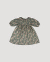 Early Sunday, Suzie Dress in Autumn Bloom Soft Green, made from Printed Cotton Double Gauze fabric, featuring classic silhouette with a ruffle neckline and mother-of-pearl buttons, shown in a back flat-lay view