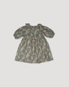 Early Sunday, Suzie Dress in Autumn Bloom Soft Green, made from Printed Cotton Double Gauze fabric, featuring classic silhouette with a ruffle neckline and mother-of-pearl buttons, shown in a front flat-lay view