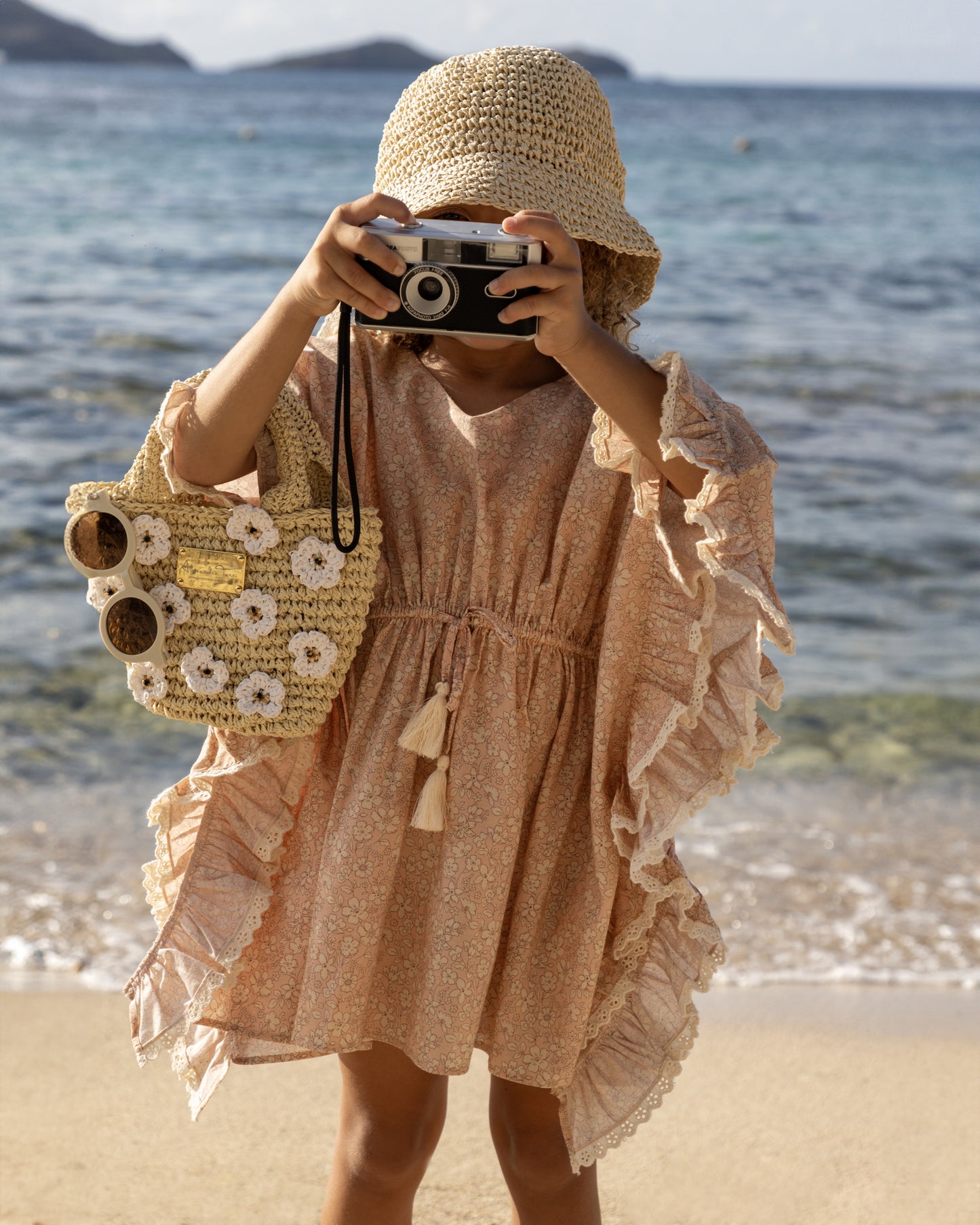 Early Sunday, Tony Kaftan in Garden Flowers print, made from Printed Cotton Cambric fabric, featuring flowing kaftan silhouette with a gathered waist and tassel tie detail, shown in a close up view of a model wearing outdoors