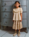 Early Sunday, Victoria Skirt in Ditsy Bouquet Cream print, made from Printed Viscose Rayon Twill fabric, featuring Tiered silhouette for natural movement and volume, shown in a side view of model wearing it