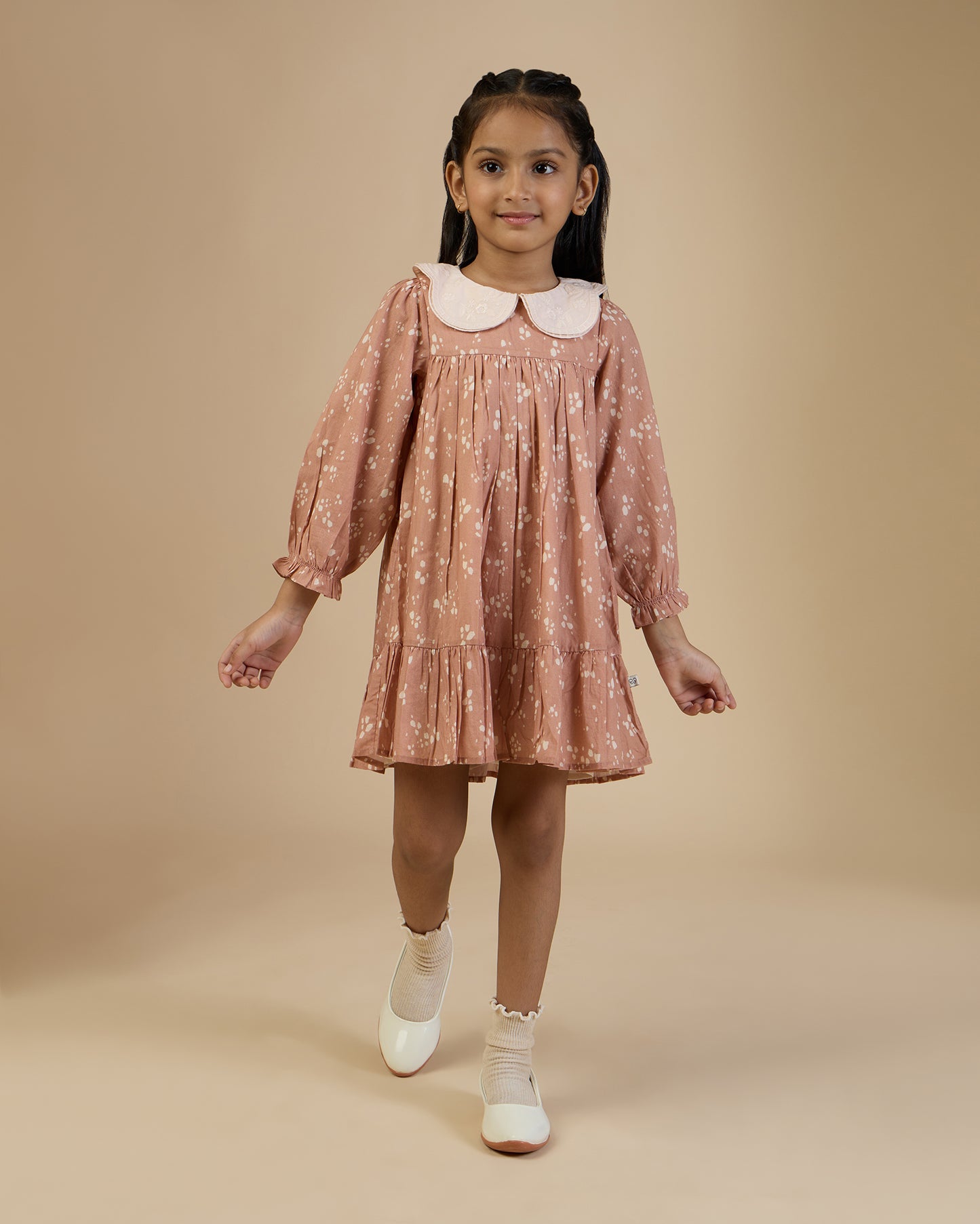Early Sunday, Virginia Dress in Fawn Soft Pinkish Brown, made from Printed Cotton Cambric fabric, featuring classic silhouette with embroidered collars, shown in a front view of model wearing it