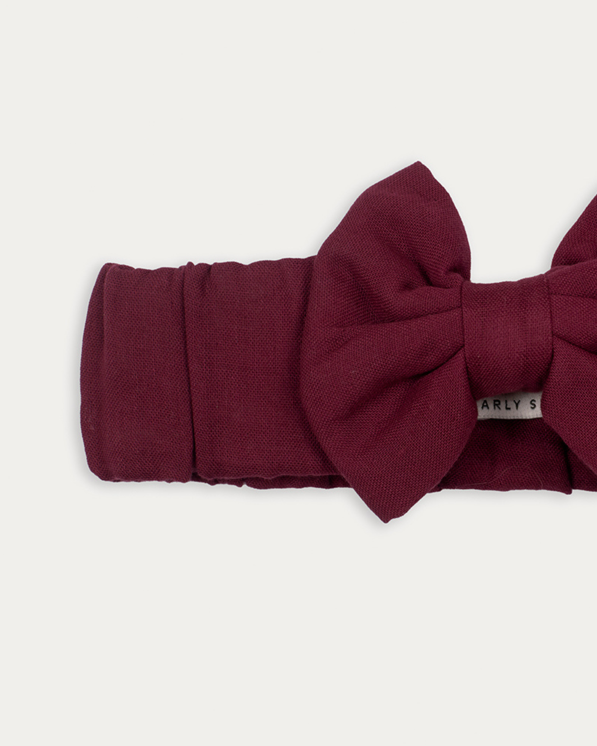 Early Sunday, Wide Bow Head Band in Plum, made from Cotton Double Gauze fabric, featuring a wide bow design, shown in a closeup flat-lay view