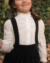 Early Sunday, Zoe Shirt in Ecru, made from Cotton Jeera Dobby Voile fabric, featuring frilled roundneck with detailed lace yoke, shown in a close up shot of model playing outdoors