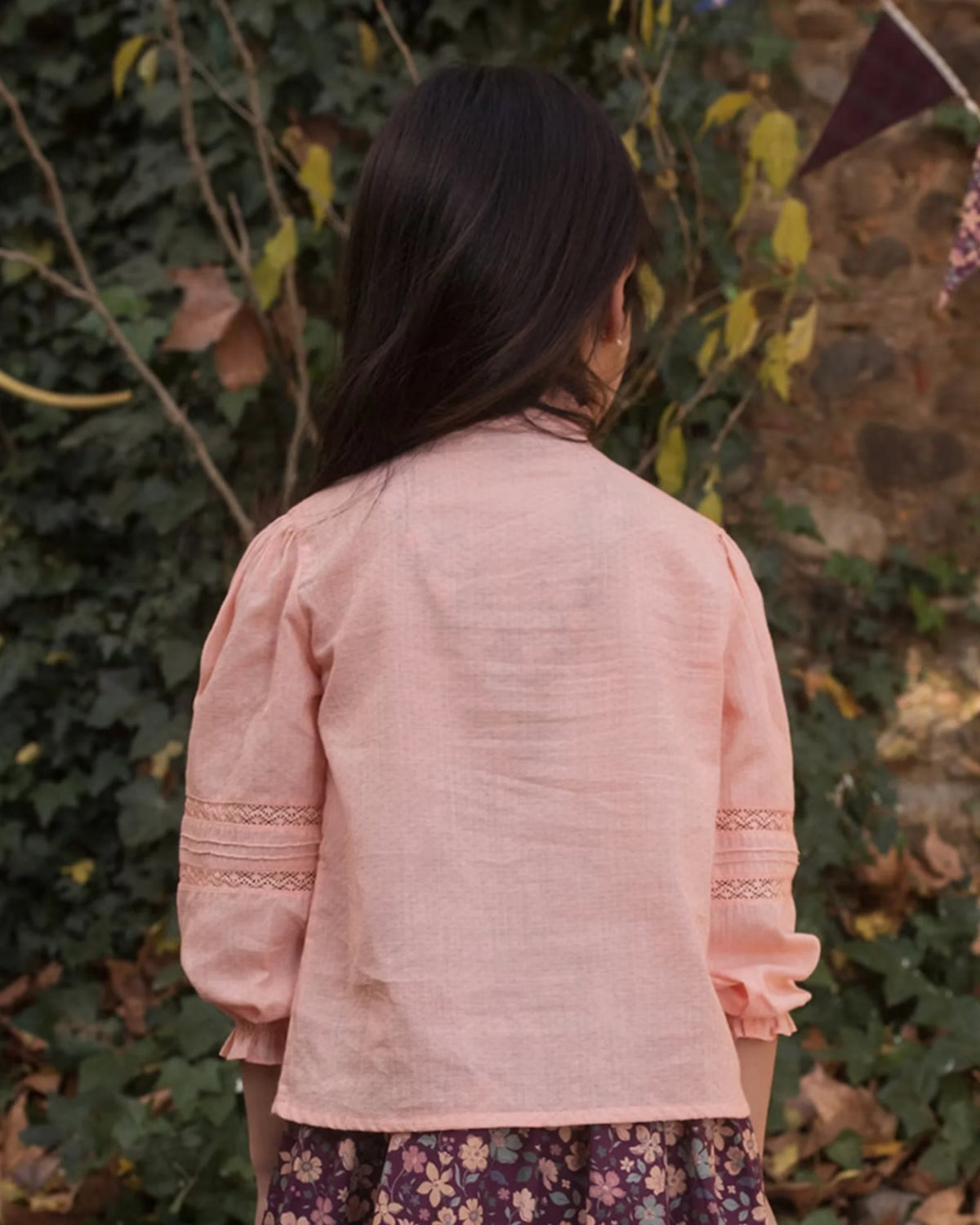 Early Sunday, Zoe Shirt in Nude, made from Cotton Jeera Dobby Voile fabric, featuring frilled roundneck with detailed lace yoke, shown in a back view of model wearing outdoors
