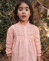 Early Sunday, Zoe Shirt in Nude, made from Cotton Jeera Dobby Voile fabric, featuring frilled roundneck with detailed lace yoke, shown in a close up shot of model playing outdoors
